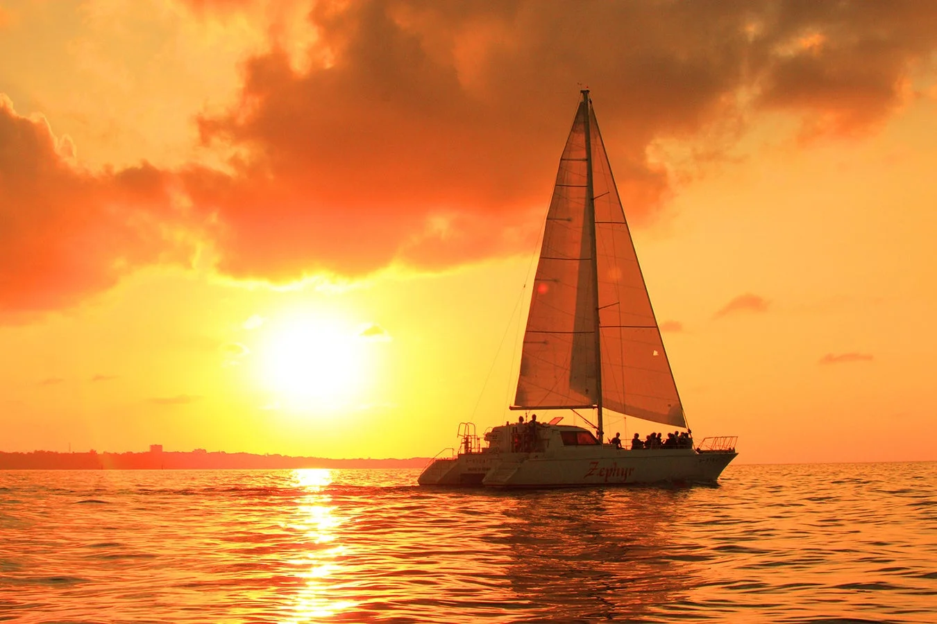 夕焼けの海を航行するカタマランヨット