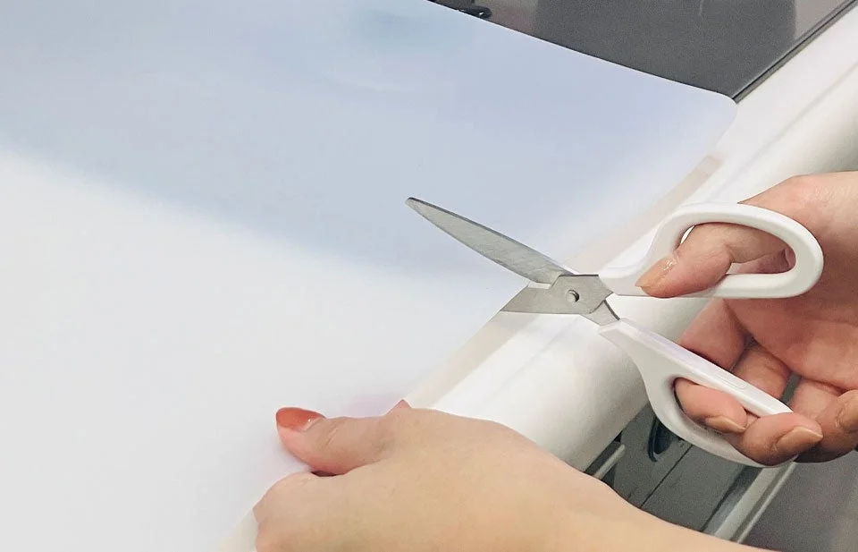 ハサミでマットを切る手元