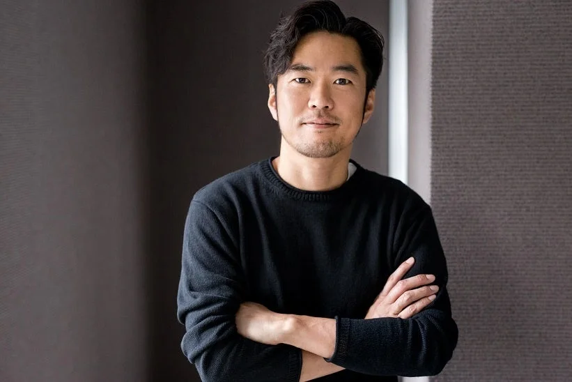 黒いセーターを着て腕を組んだアジア人男性のポートレート