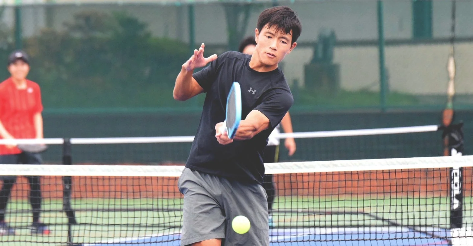 ピックルボールコートでパドルでボールを打ち返している竹山世成選手