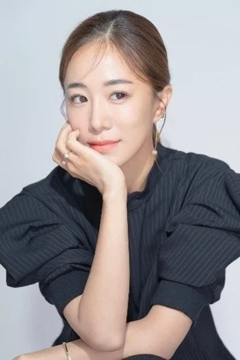 白い背景の前で、黒いストライプのトップスを着たアジア人女性のポートレートです