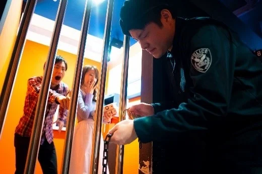 警察官と牢屋の中にいる男女の様子