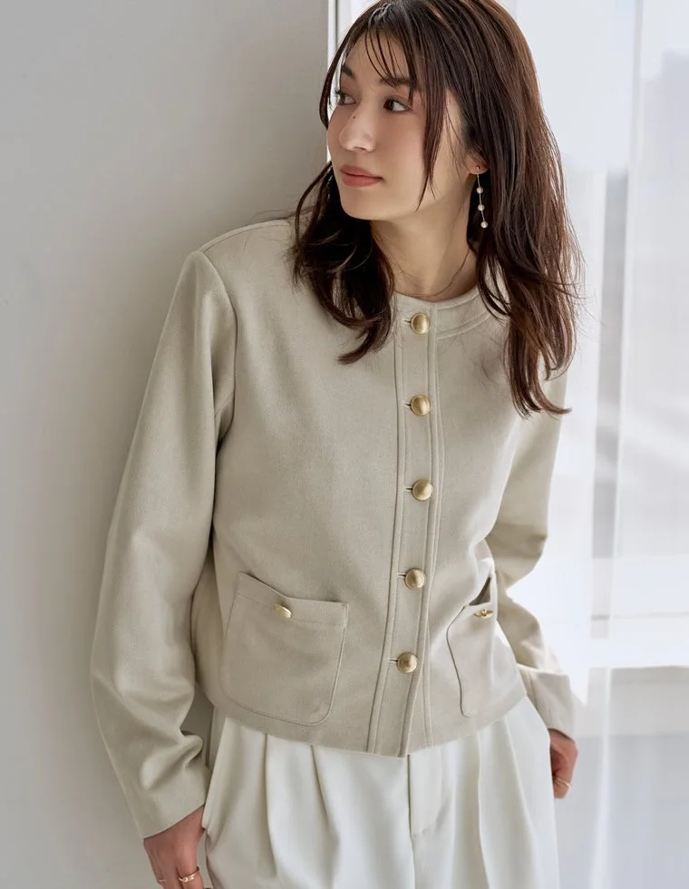 ベージュの金ボタンジャケットと白のワイドパンツを合わせた女性の全身ファッション