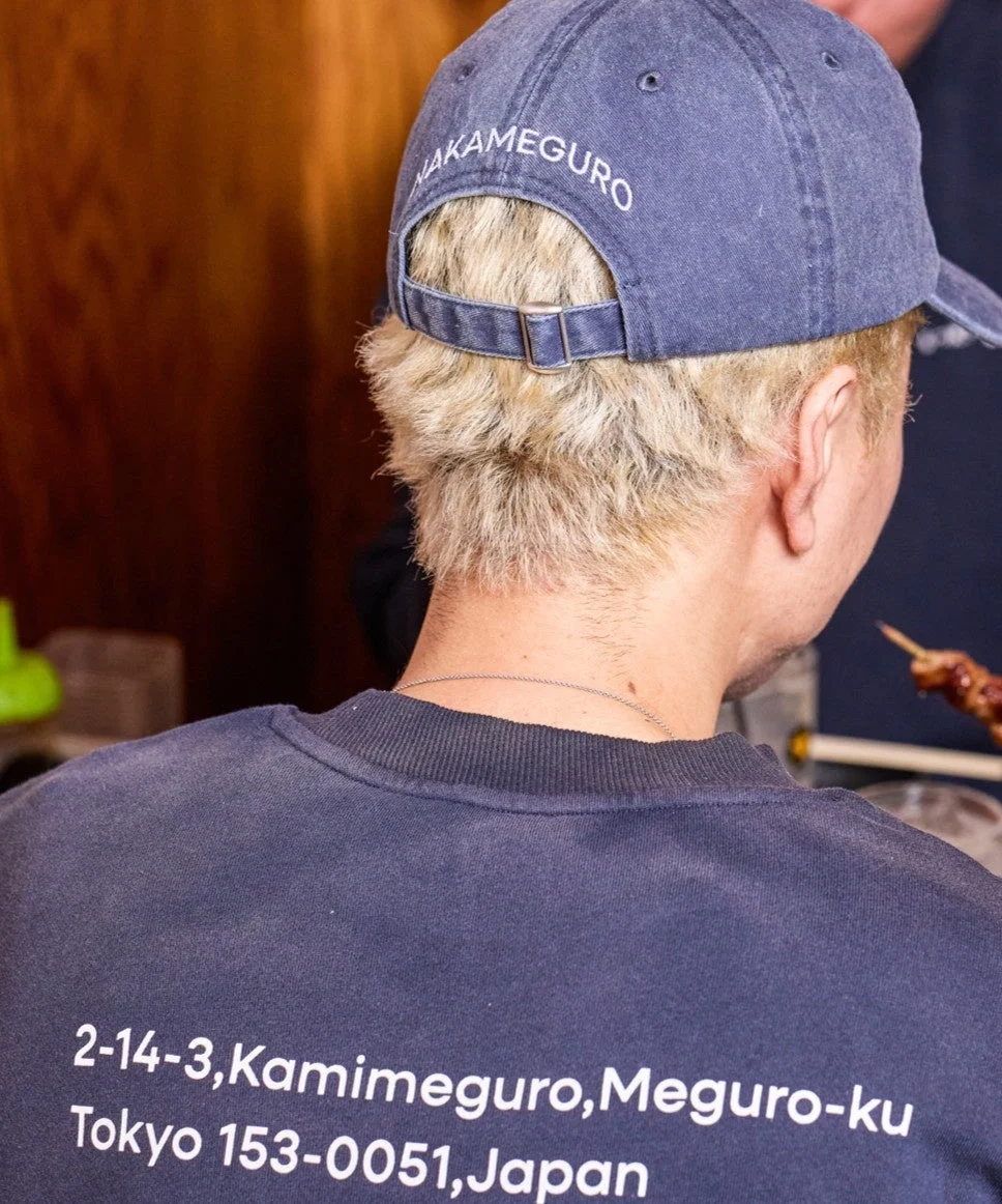 「NAKAMEGURO」キャップとスウェットの後ろ姿