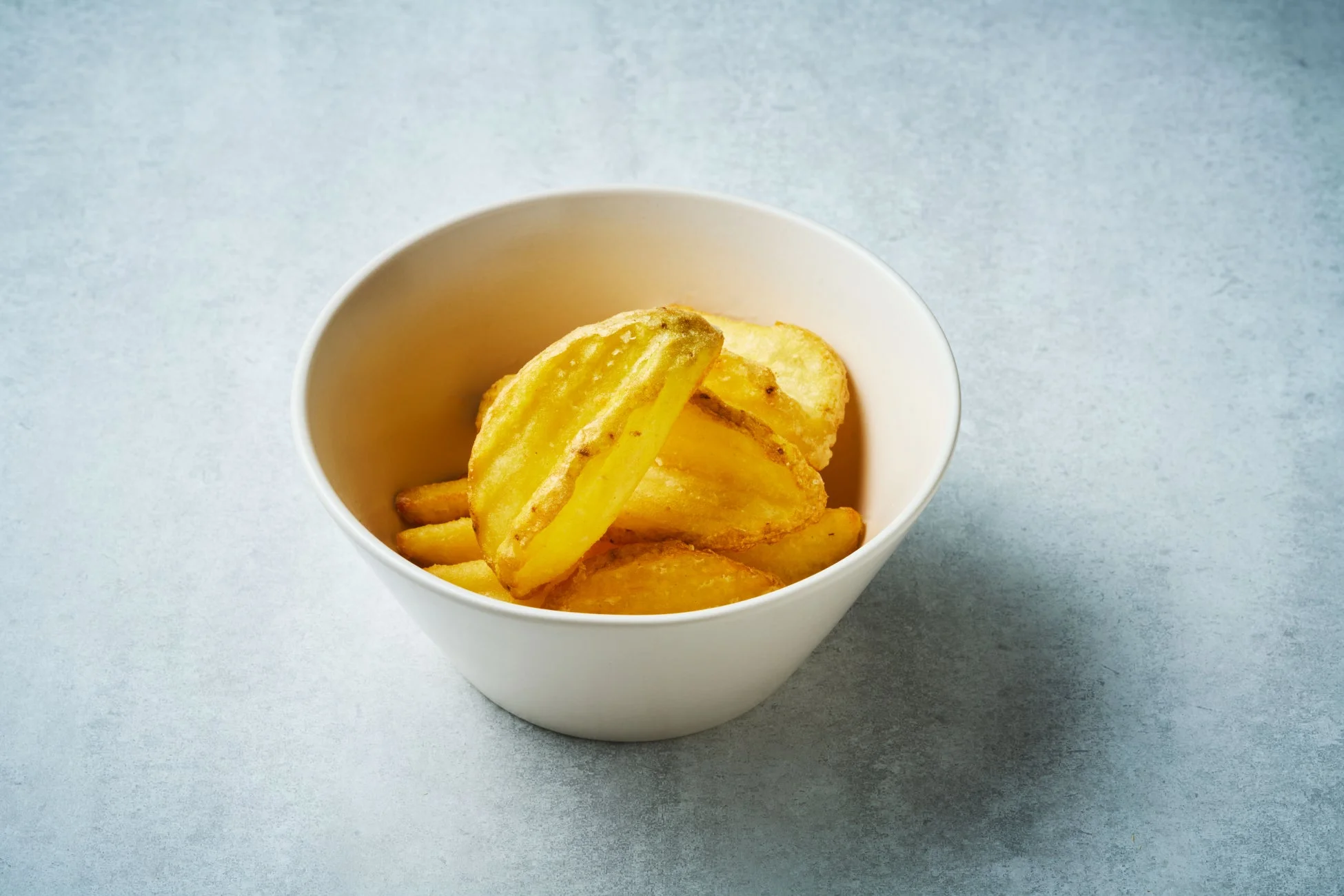 皮付きで厚切りにされた黄金色のポテトウェッジ