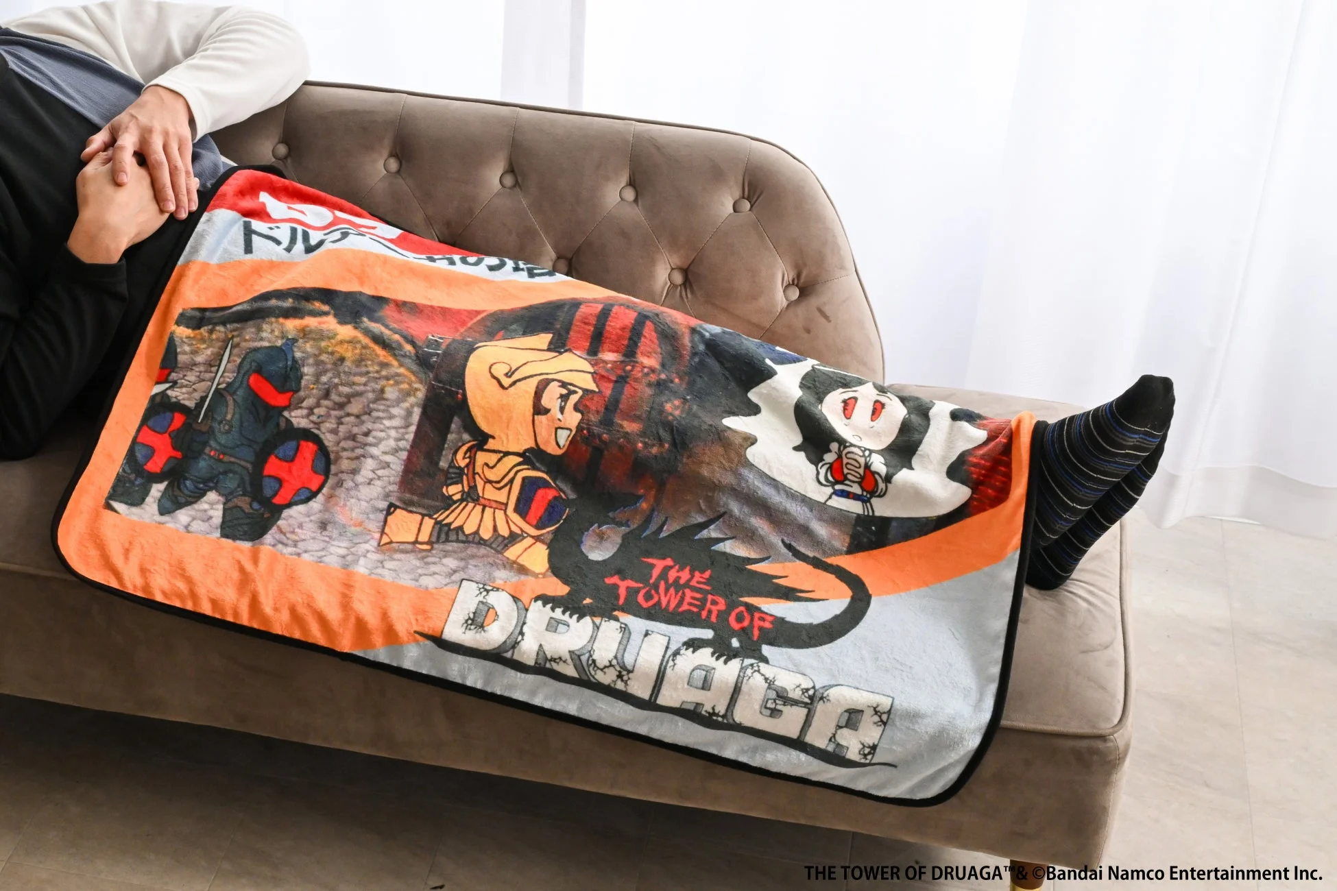 ソファでドルアーガの塔ブランケットを使用する様子