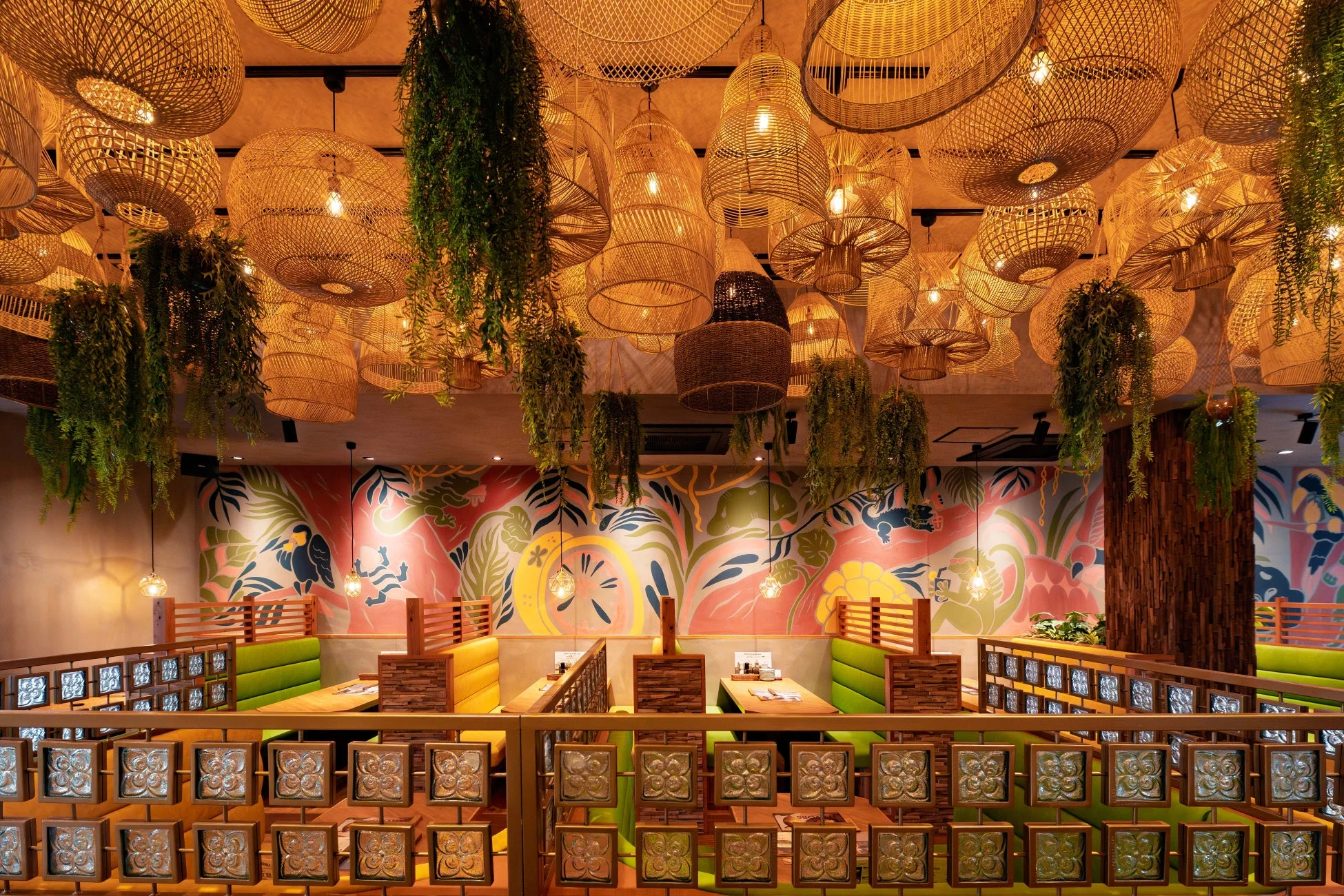 多数のラタン製照明と吊り下げ植物が天井を彩る、トロピカルでエキゾチックな雰囲気のレストラン