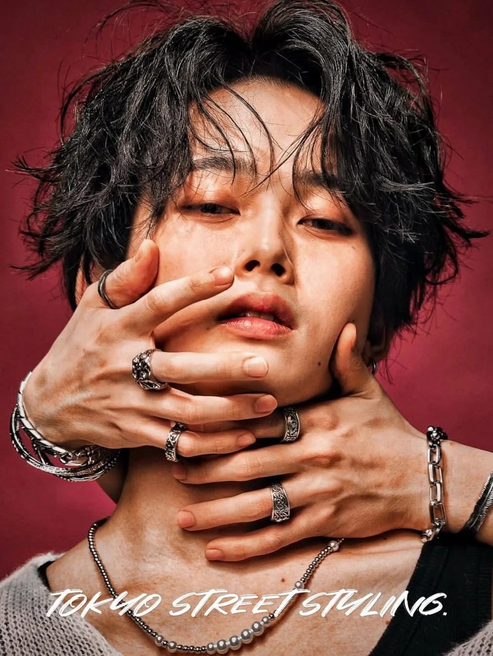 複数のシルバーアクセサリーを身につけた黒髪の人物のポートレート