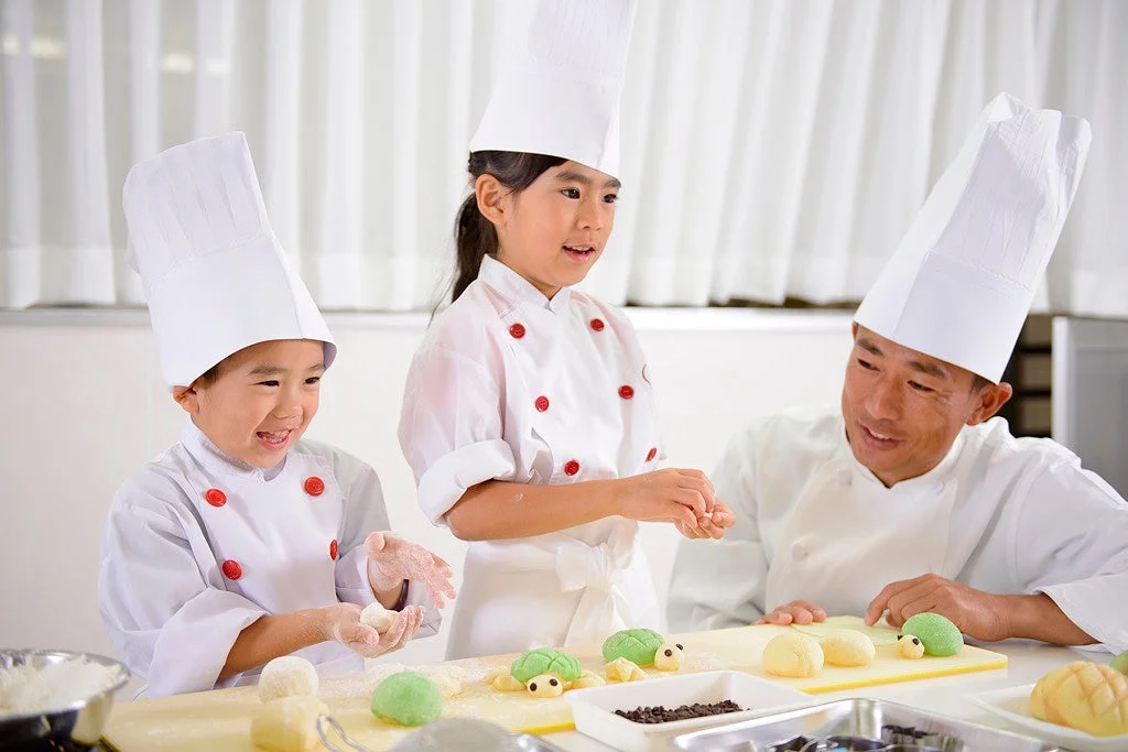 コック帽をかぶった子供たちがパン作りを楽しむ様子