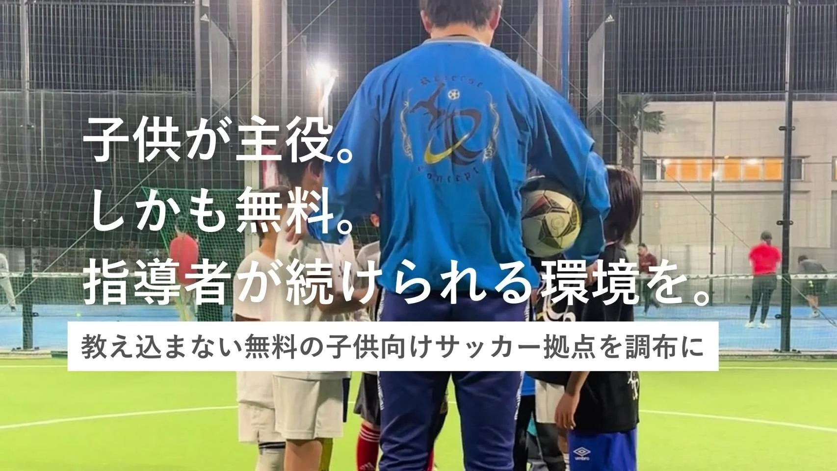 サッカーグラウンドで子供たちと大人が集まっている様子