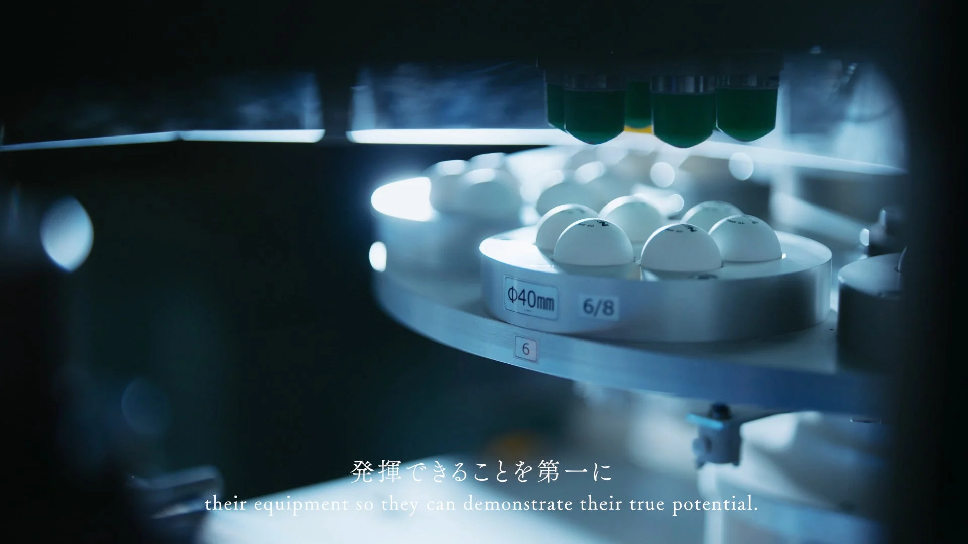 製造ラインで白い部品に液体が充填される様子