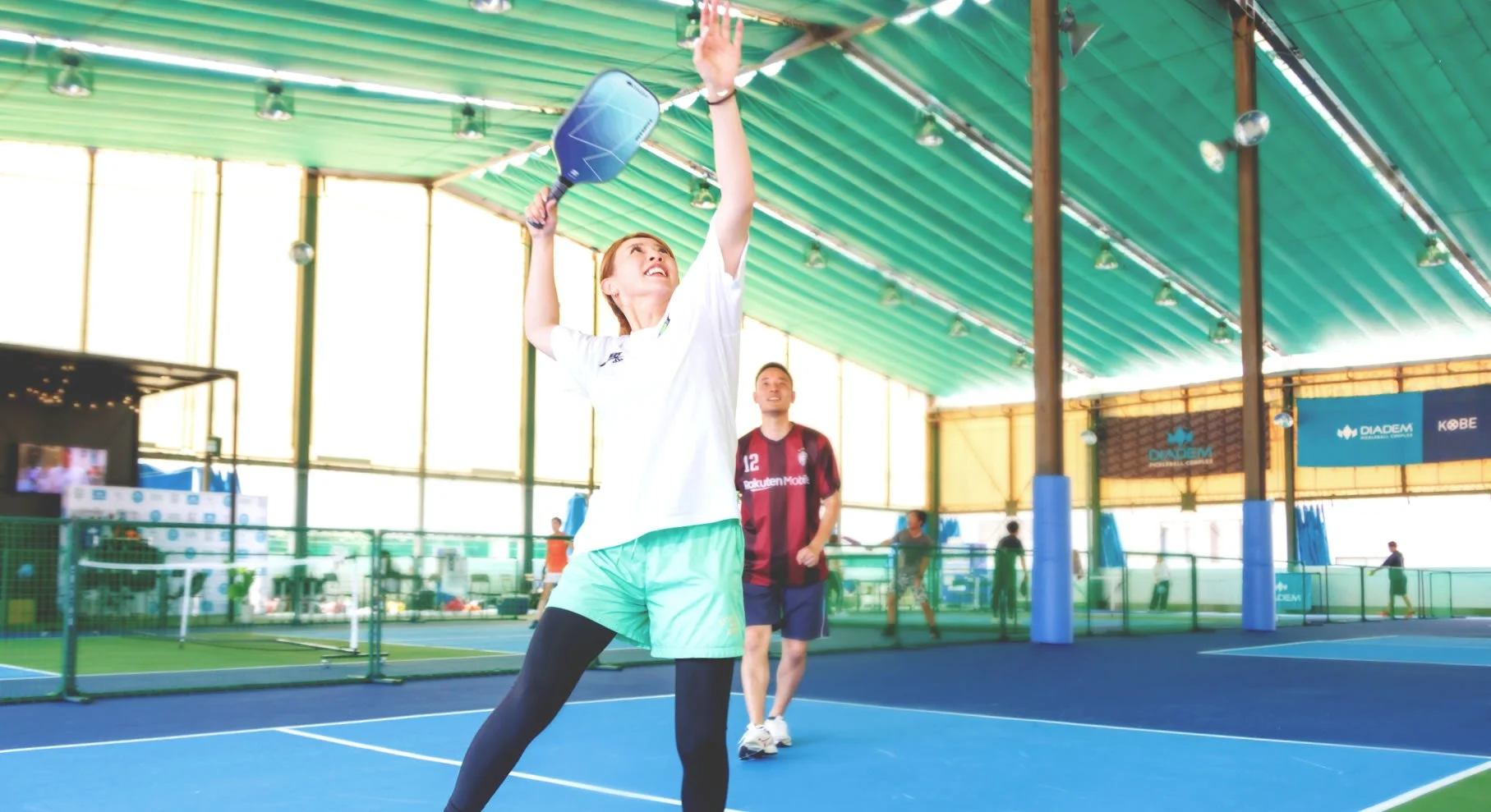 屋内コートでピックルボールを楽しむ人々