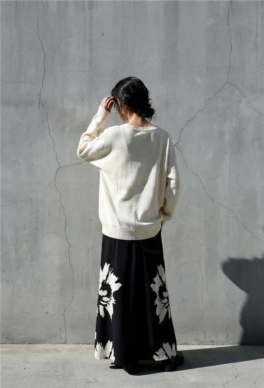 クリーム色セーターと花柄スカートの後ろ姿