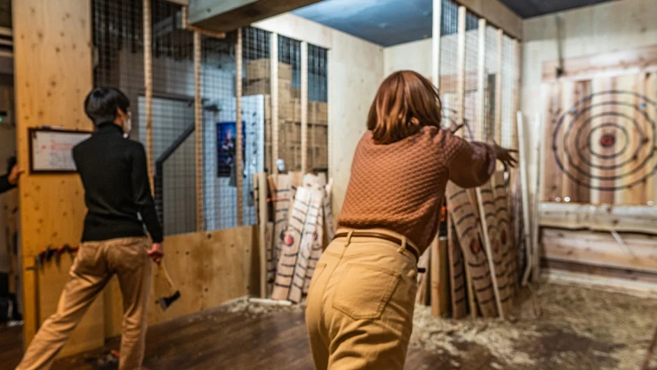 屋内で斧投げを楽しむ人々