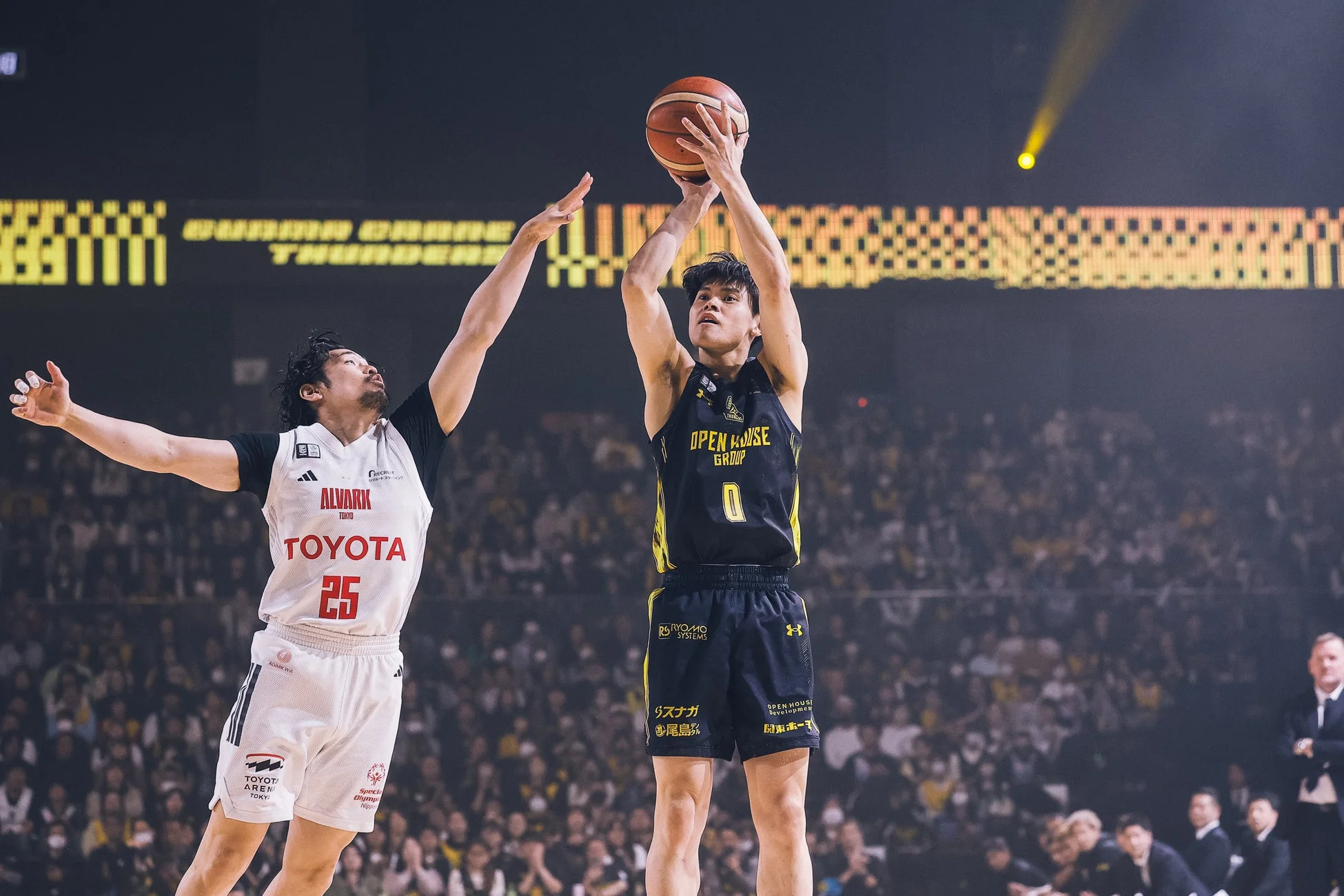 バスケットボールの試合中、シュートを放つ選手とそれをブロックしようとする選手