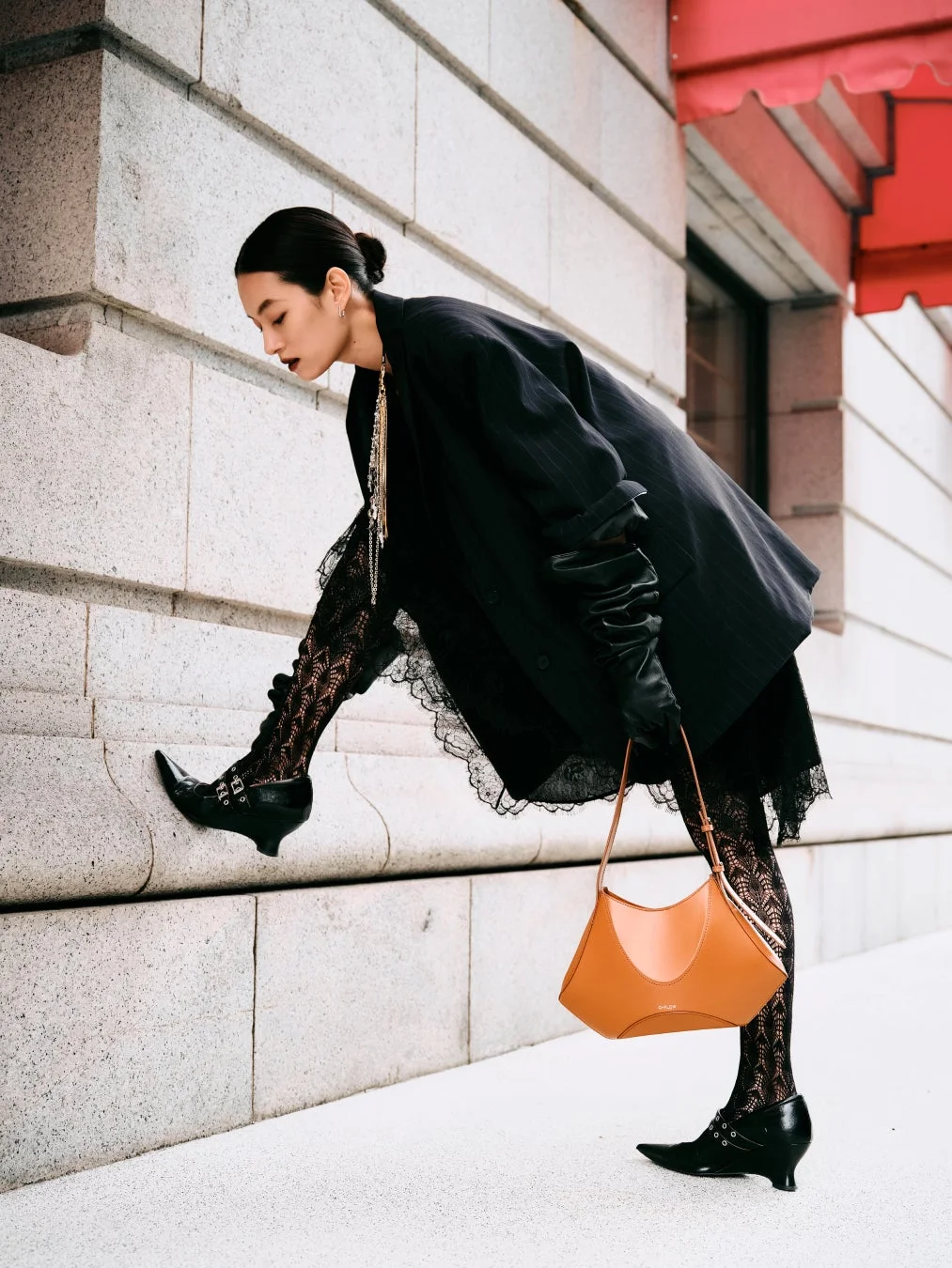 黒いジャケットと茶色のバッグを身につけた女性