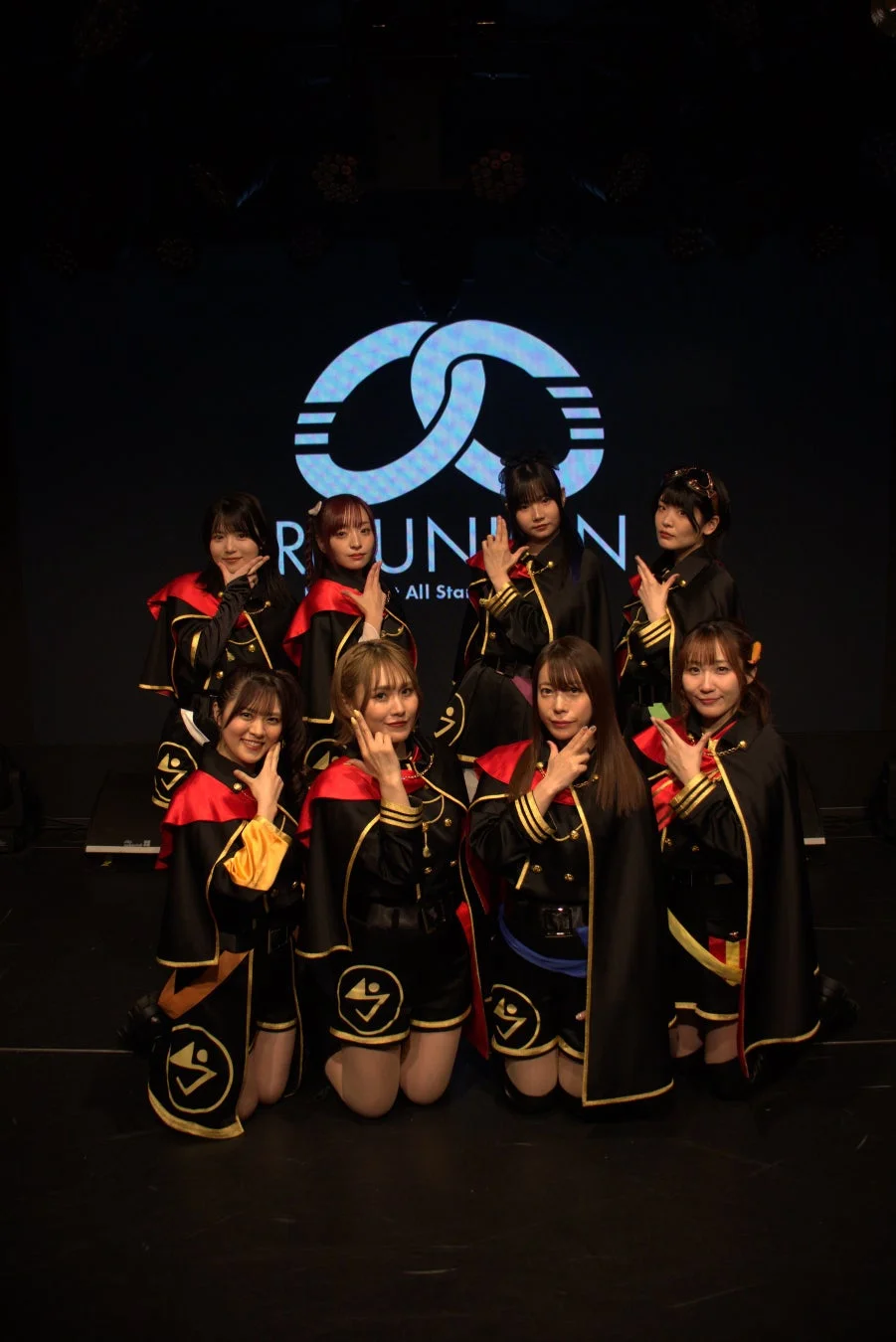 ステージでパフォーマンスする8人組アイドルグループ