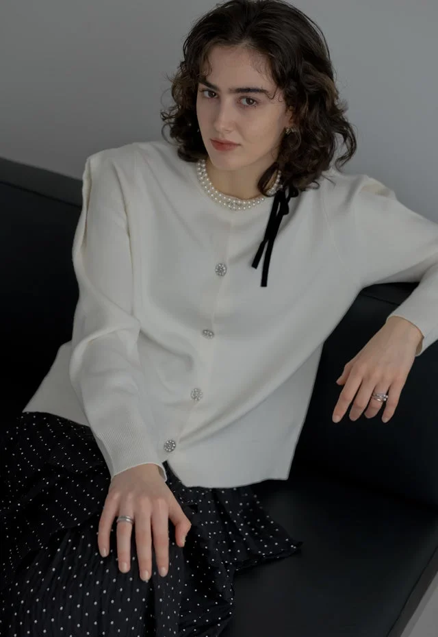 白いカーディガンとドット柄スカートのルック