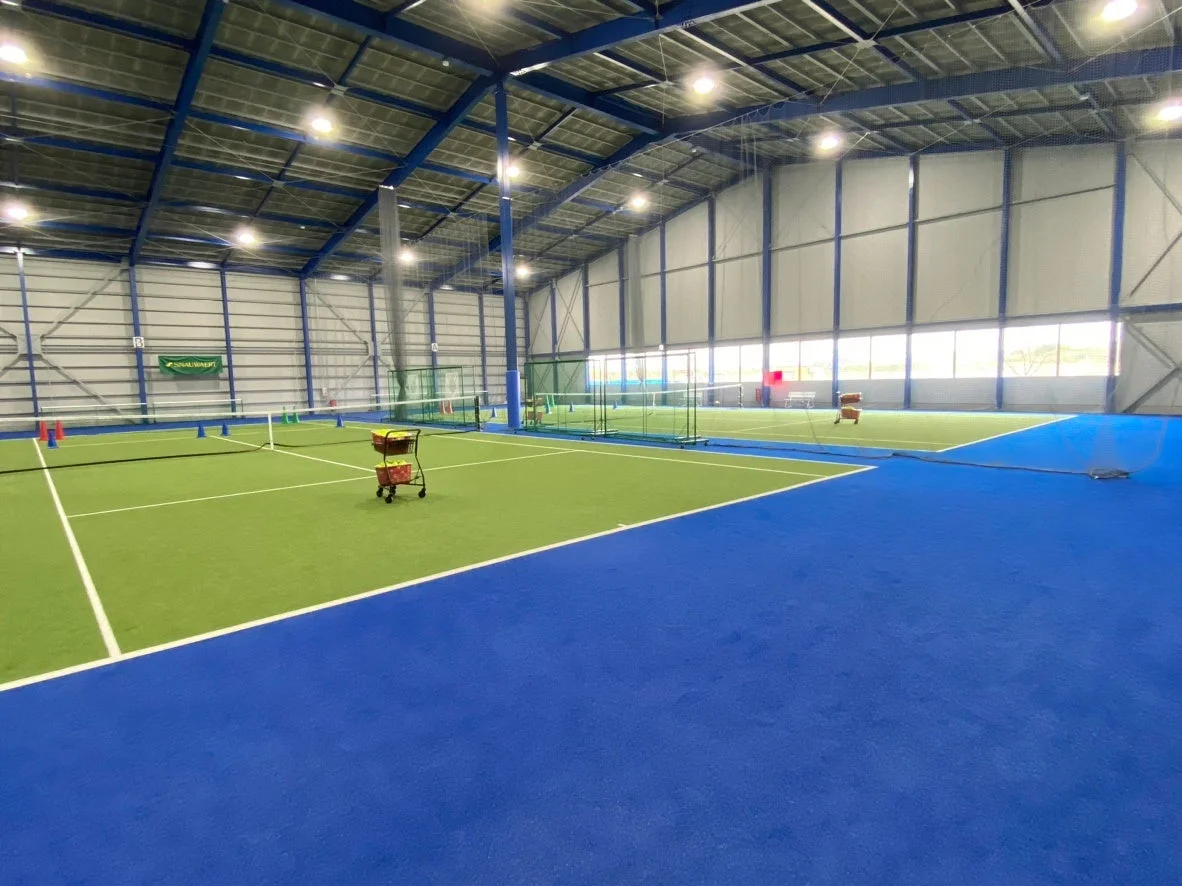 広々とした室内テニスコートの風景
