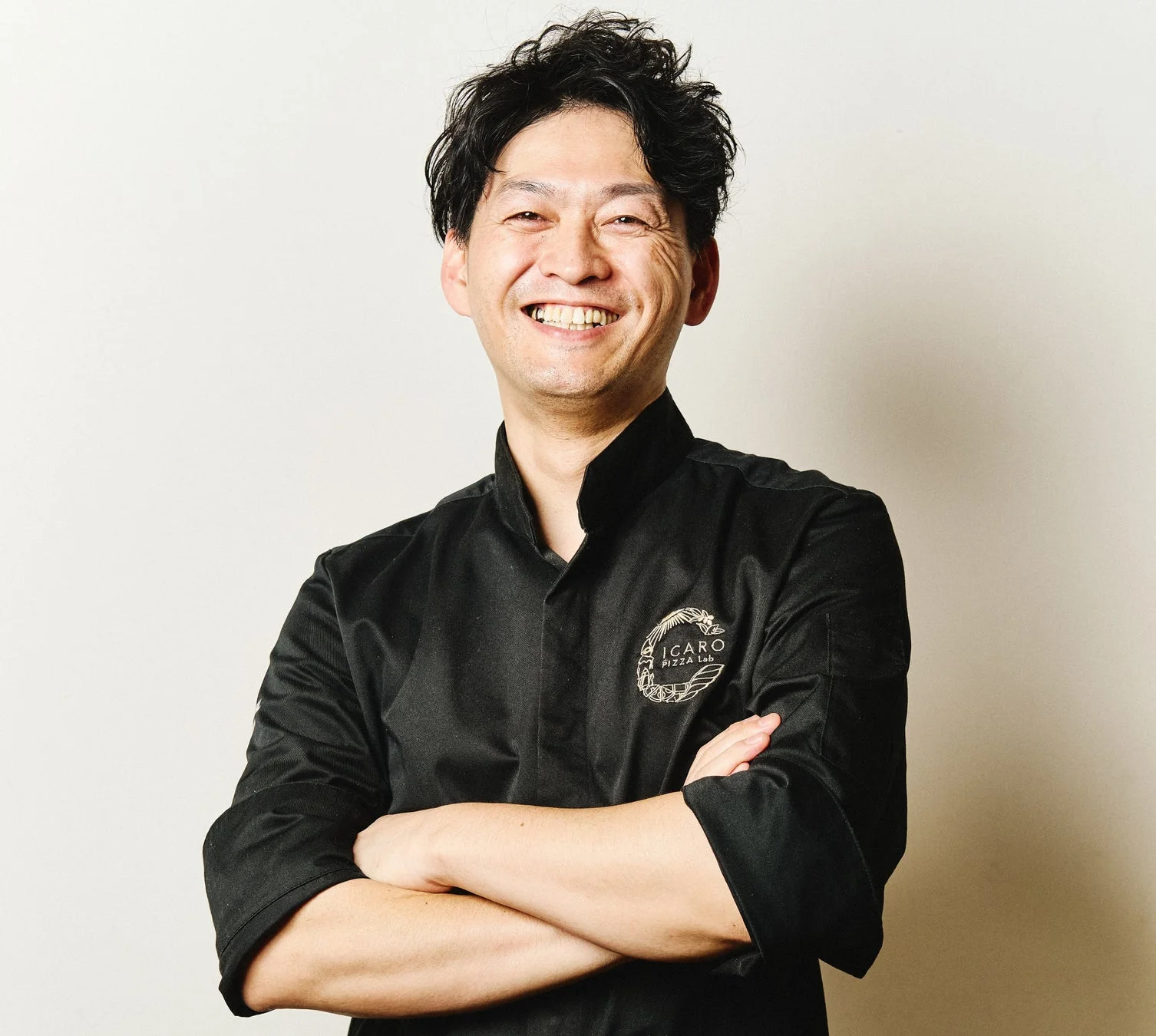 黒いコック服を着て笑顔の男性シェフ