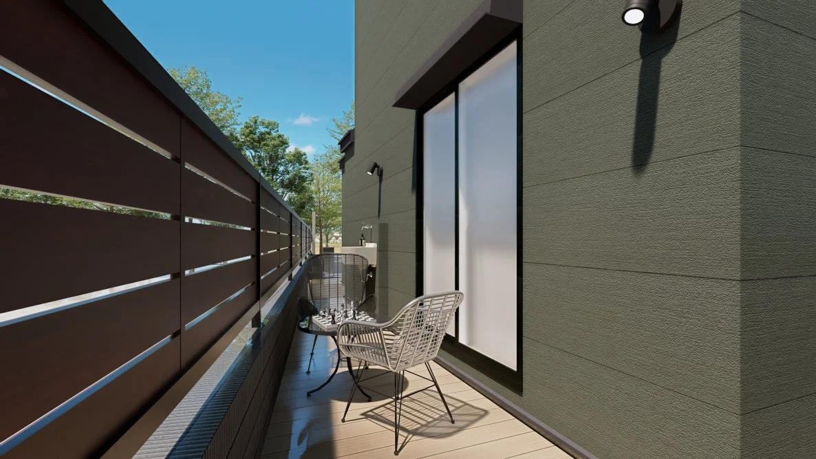 モダンな住宅のバルコニーで、チェス盤が置かれたテーブルと椅子が配置されています。木目調の床とダークブラウンのフェンスが特徴的で、屋外でのくつろぎの時間を演出する空間です。