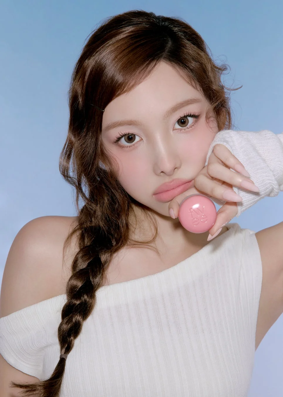 女性モデルがピンクの球体状の化粧品を持つ