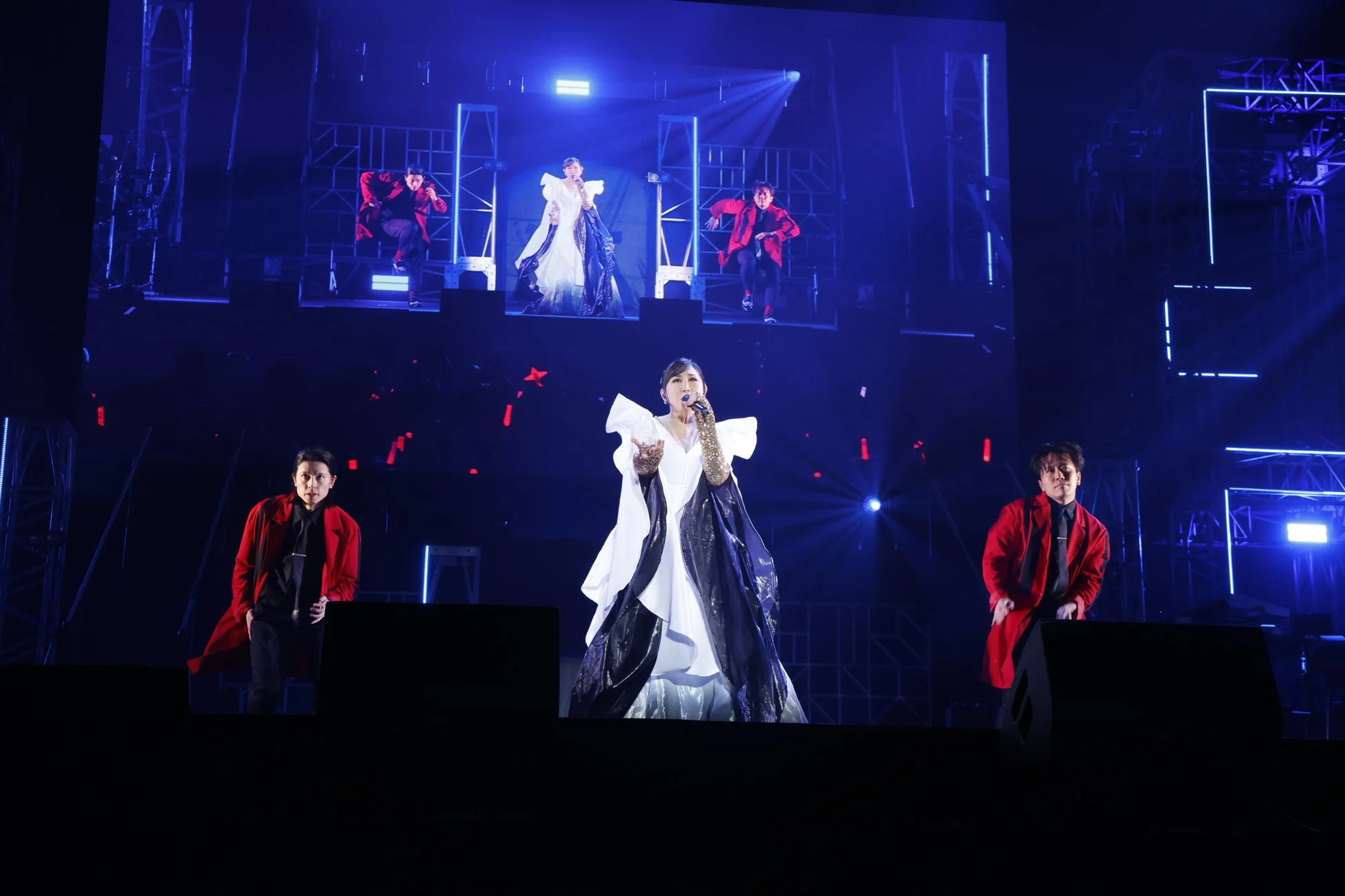 青い照明に照らされたステージで歌唱する高橋洋子