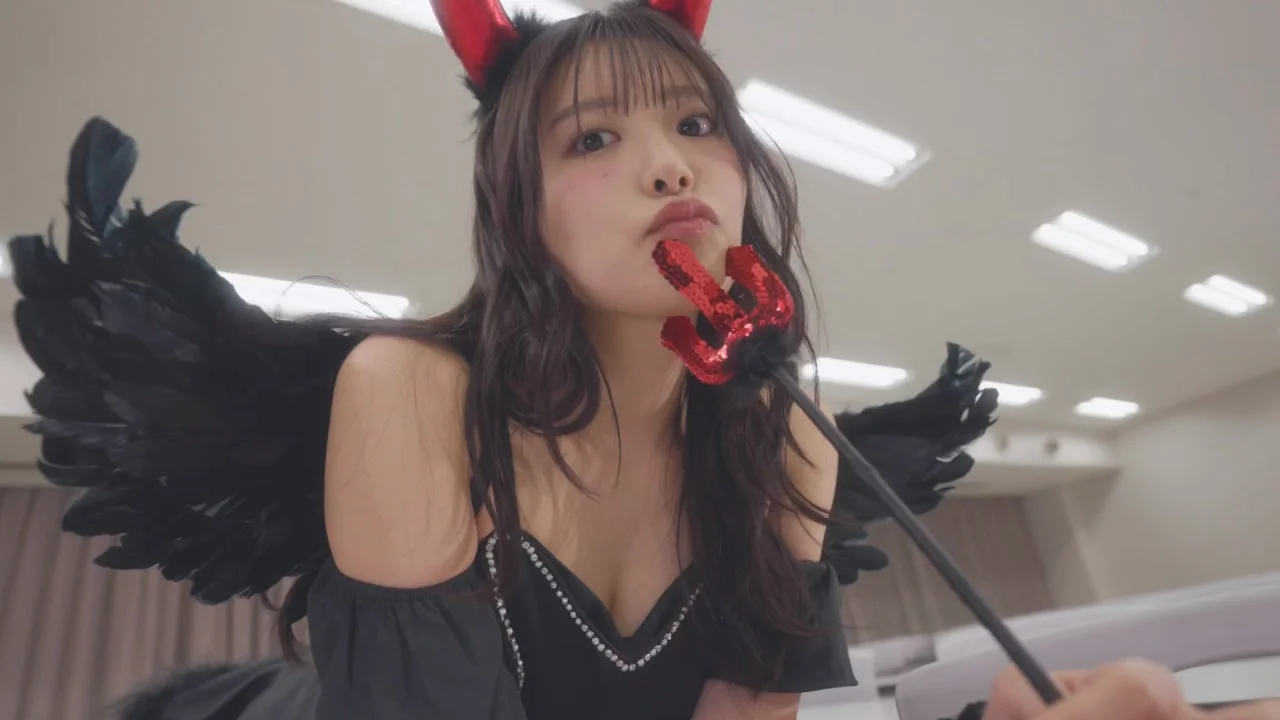 赤い角と黒い羽根のデビルコスチュームを着た若い女性