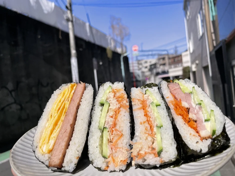 屋外で白い皿に盛り付けられた4つのおにぎり