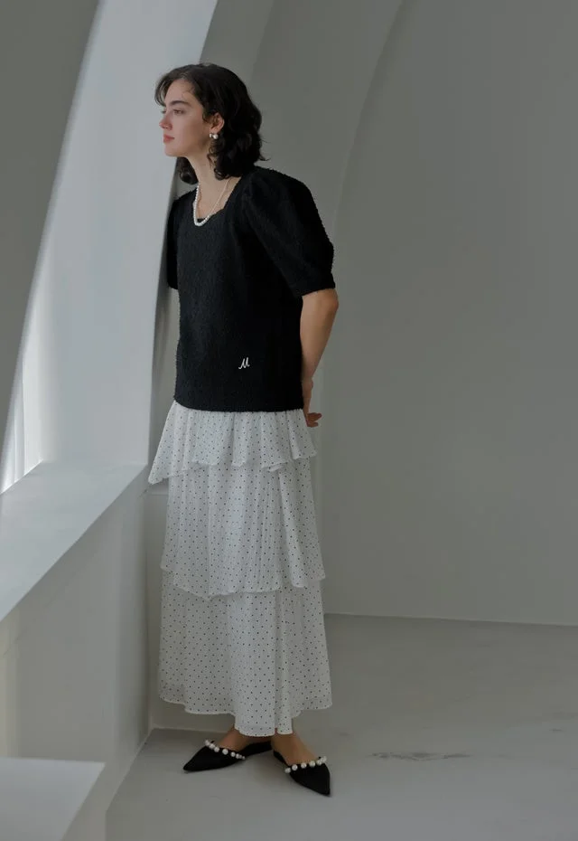 黒トップスとドット柄ティアードスカートのルック