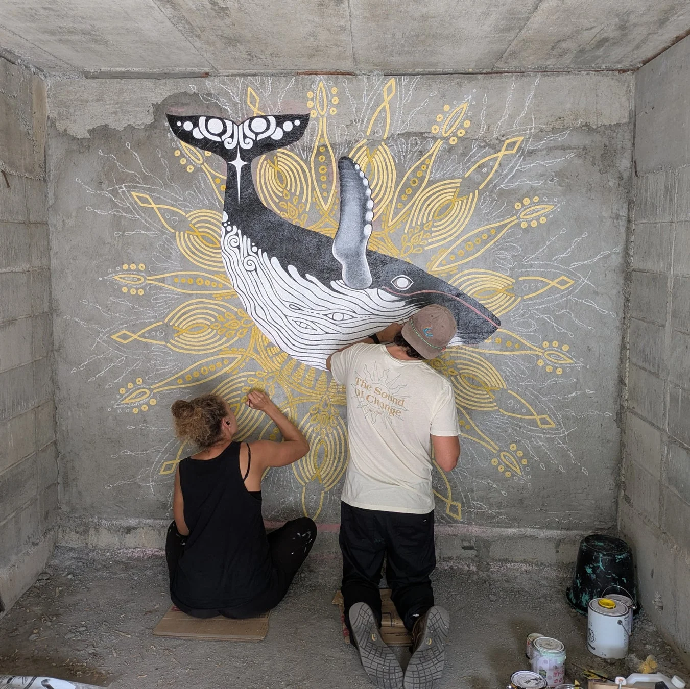クジラの壁画を描くアーティスト