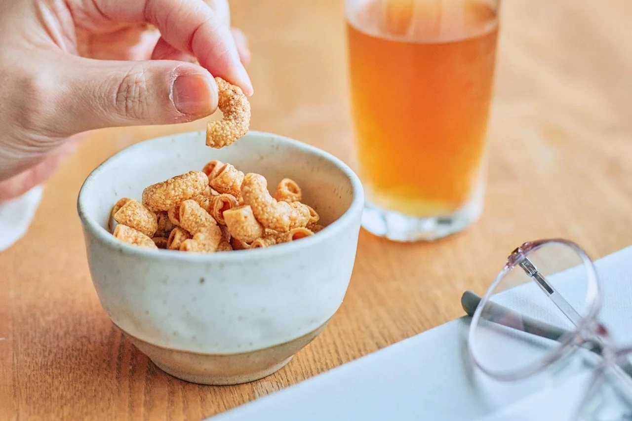 手がスナックをつまむ様子