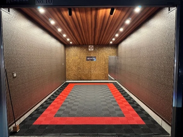 赤と黒のタイル張りの床と木目調の天井が特徴的なガレージ