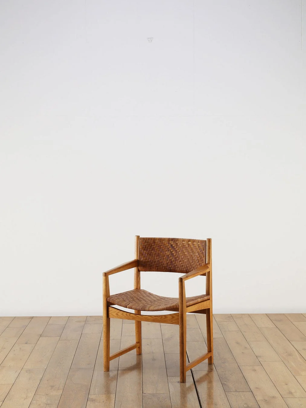 木製のフレームに編み込みの座面と背もたれを持つ椅子