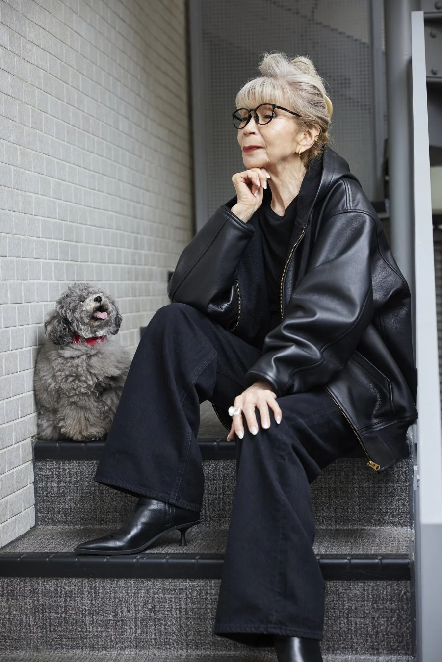 階段に座る川邉サチコ氏と犬