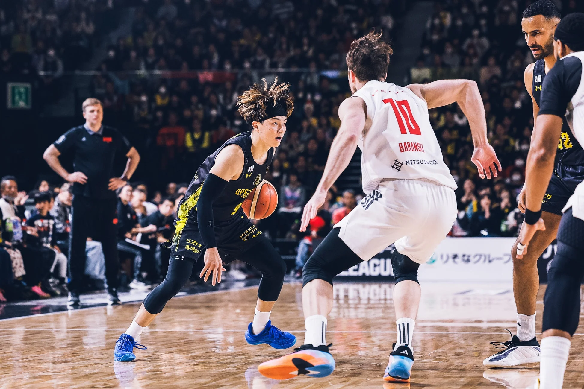 バスケットボールの試合中、ボールをドリブルし相手選手がディフェンスについている瞬間