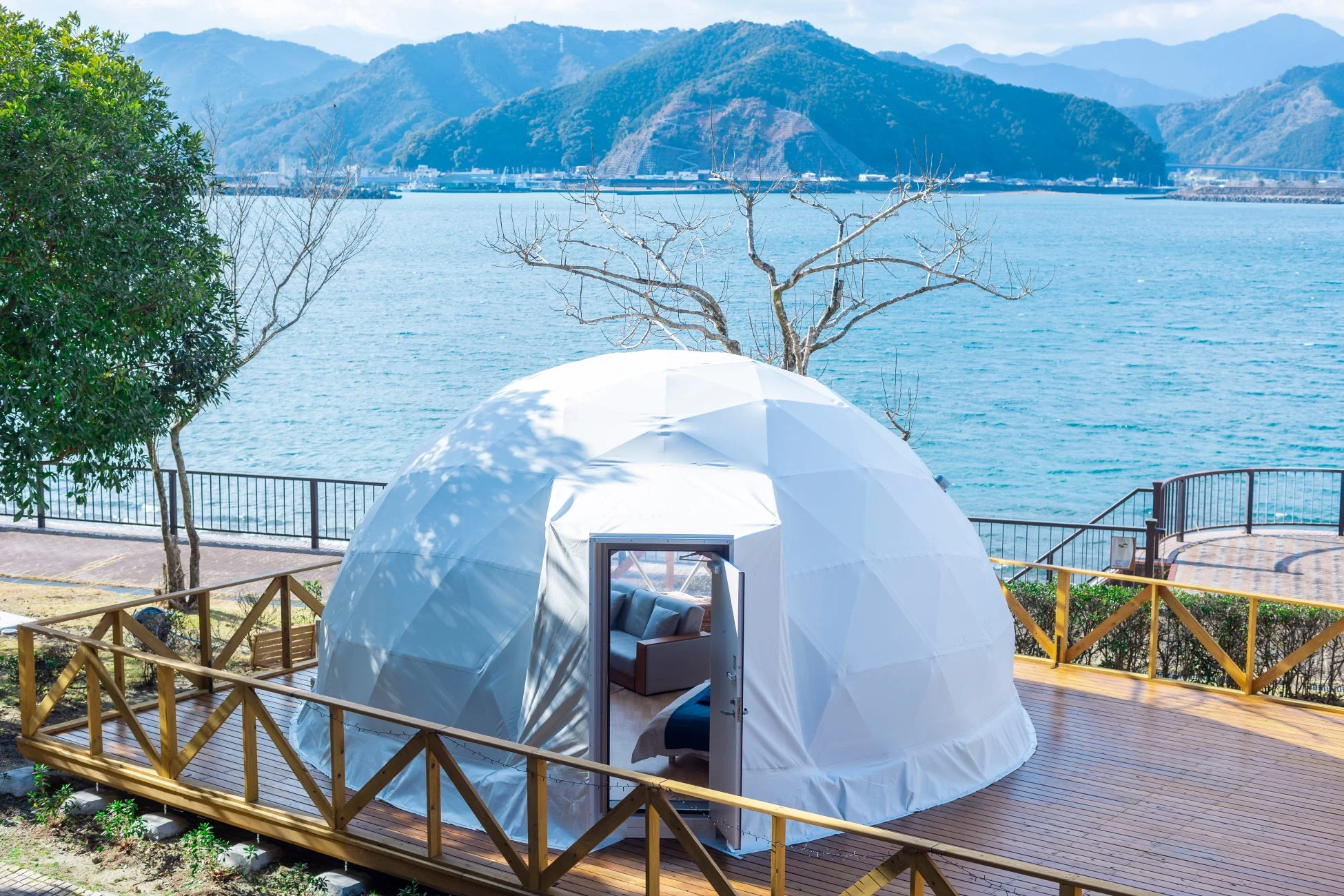 海を望む木製デッキに設置された白いドーム型テント