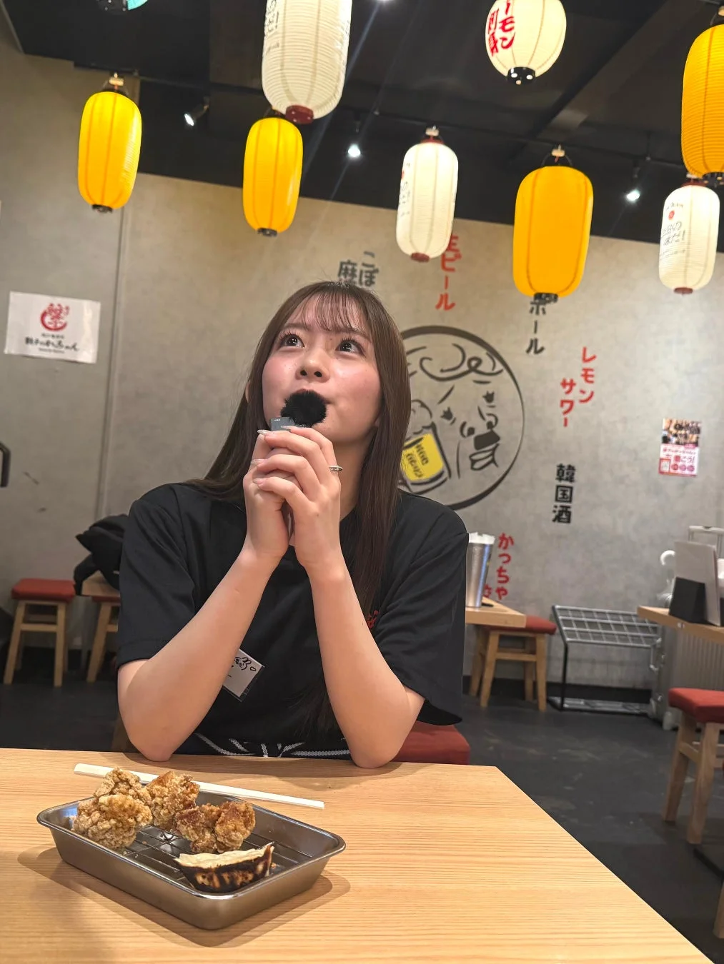 居酒屋でマイクを持つ女性