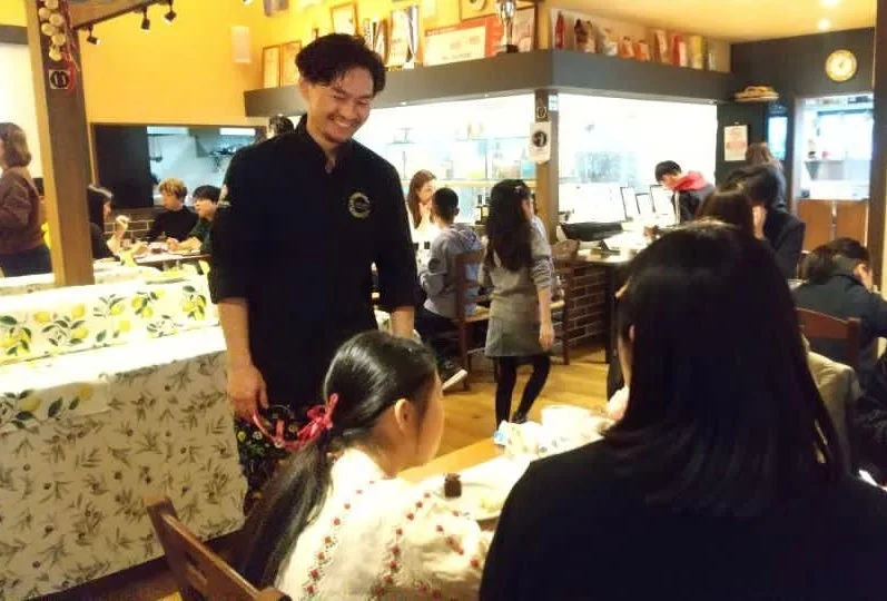 店内で客と交流する男性スタッフ