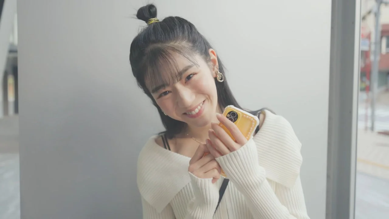 笑顔でスマートフォンを持っている若い女性