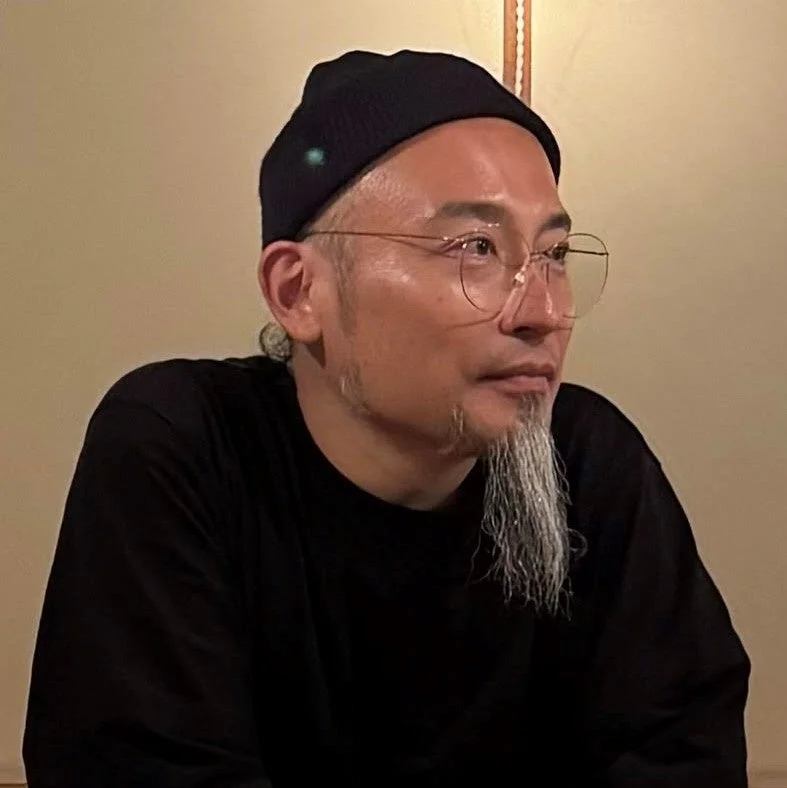 黒いビーニー帽と丸い眼鏡をかけた男性のポートレート