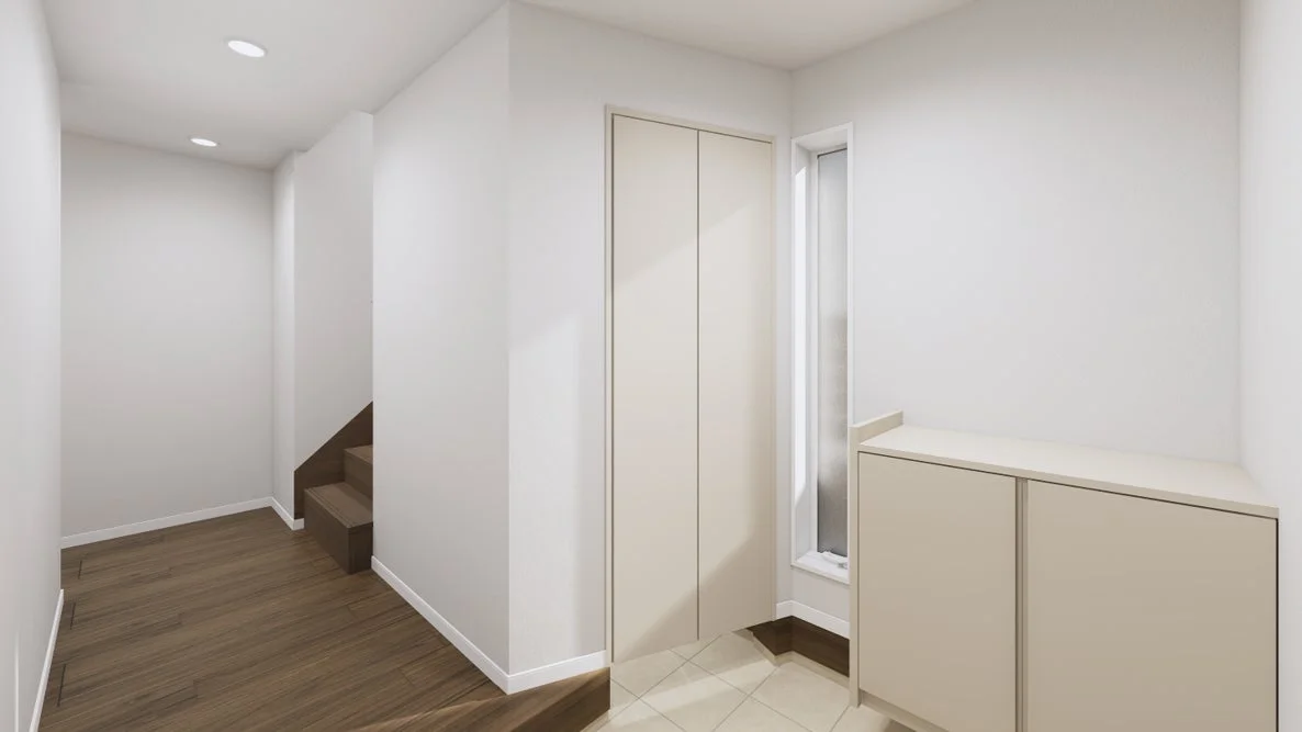 白を基調としたモダンな住宅の玄関または廊下です。木目調のフローリングと階段があり、奥には収納とドアが見えます。