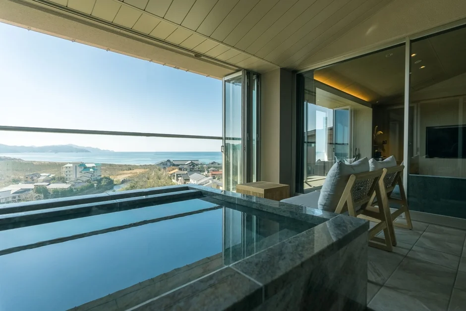 バルコニーの露天風呂から海と町並みを望む絶景