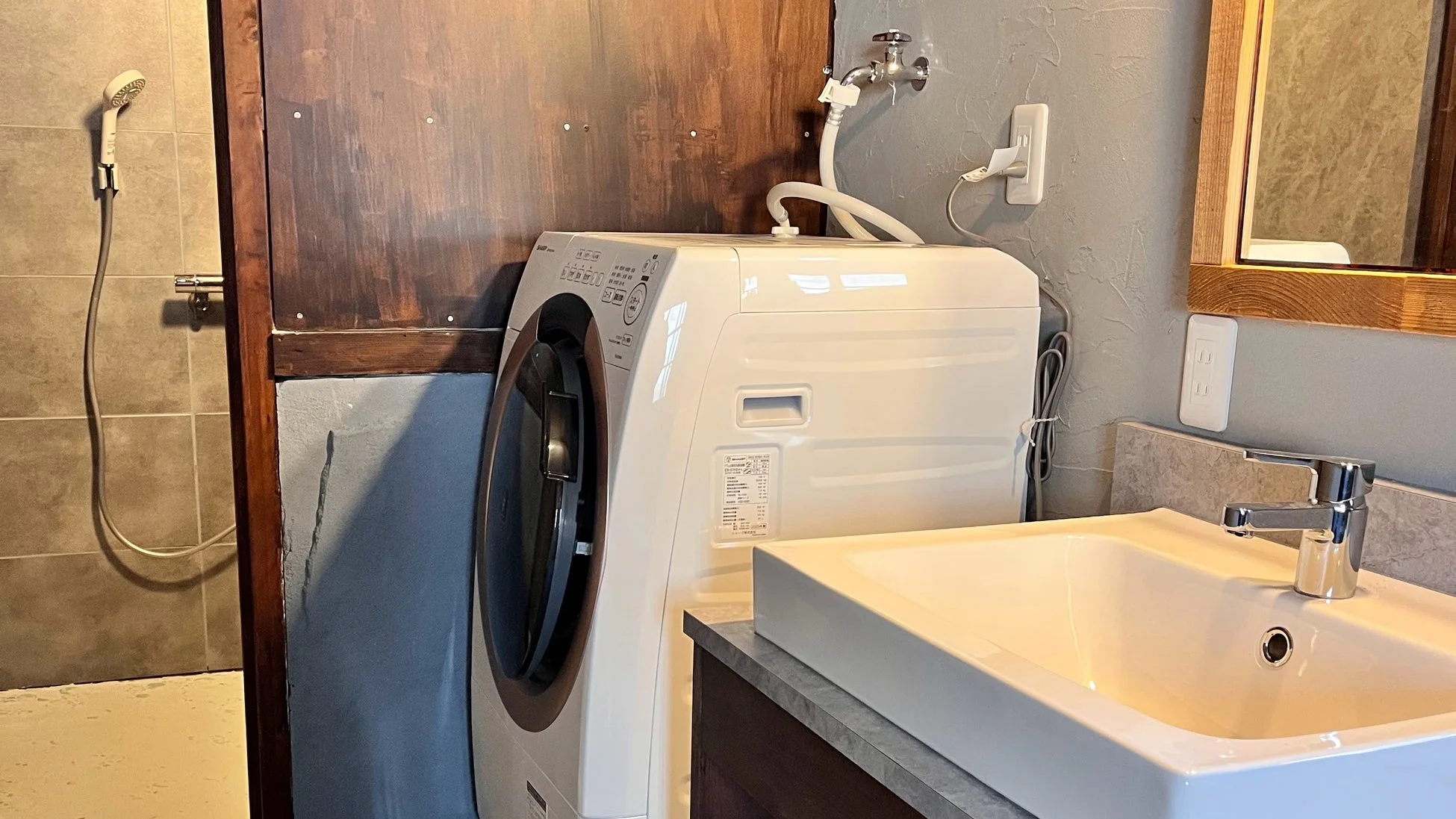 洗濯機とシャワーのあるランドリースペース