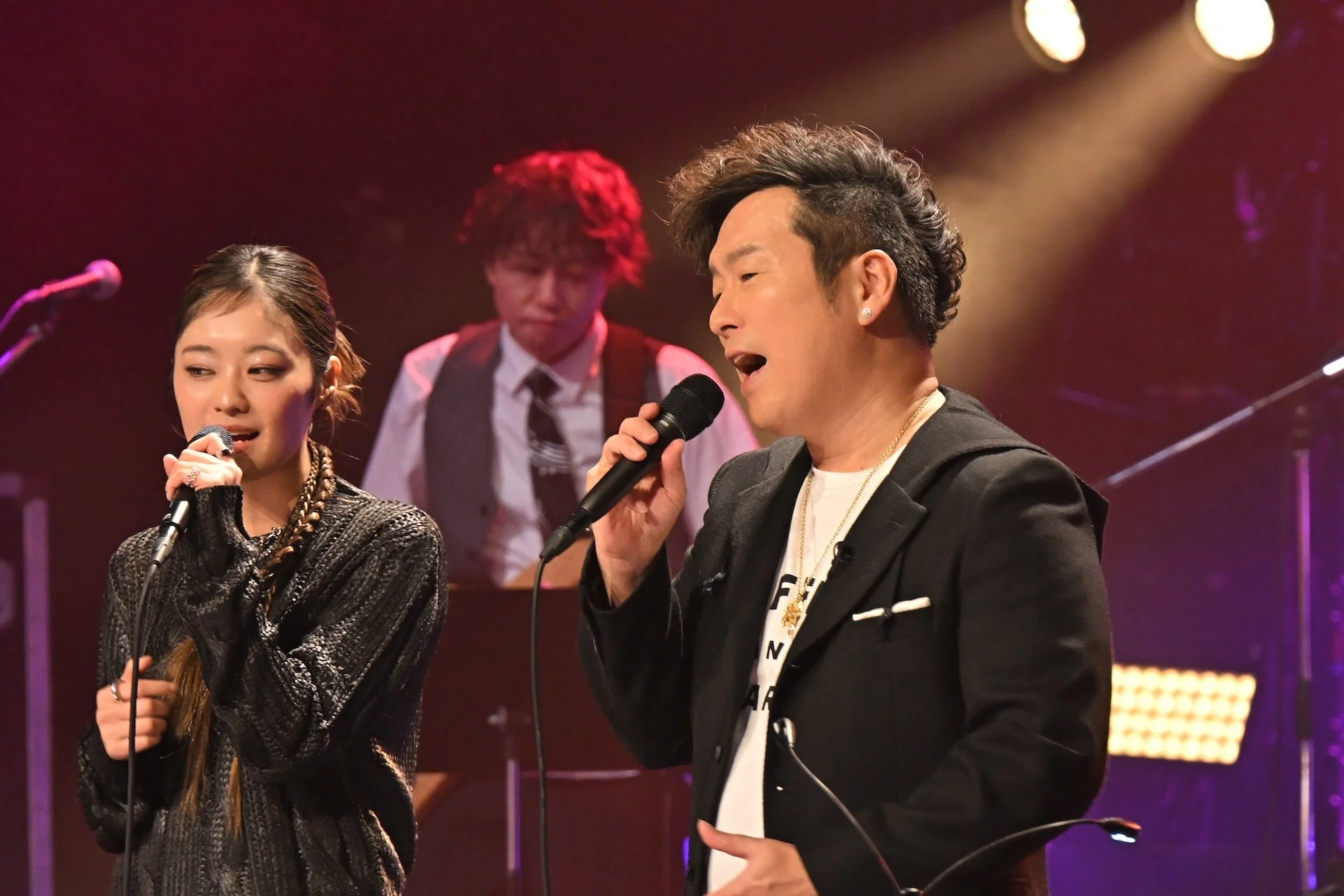ステージ上でマイクを持って歌唱する黒沢薫と吉柳咲良
