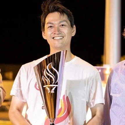 笑顔でトロフィーを持つ男性