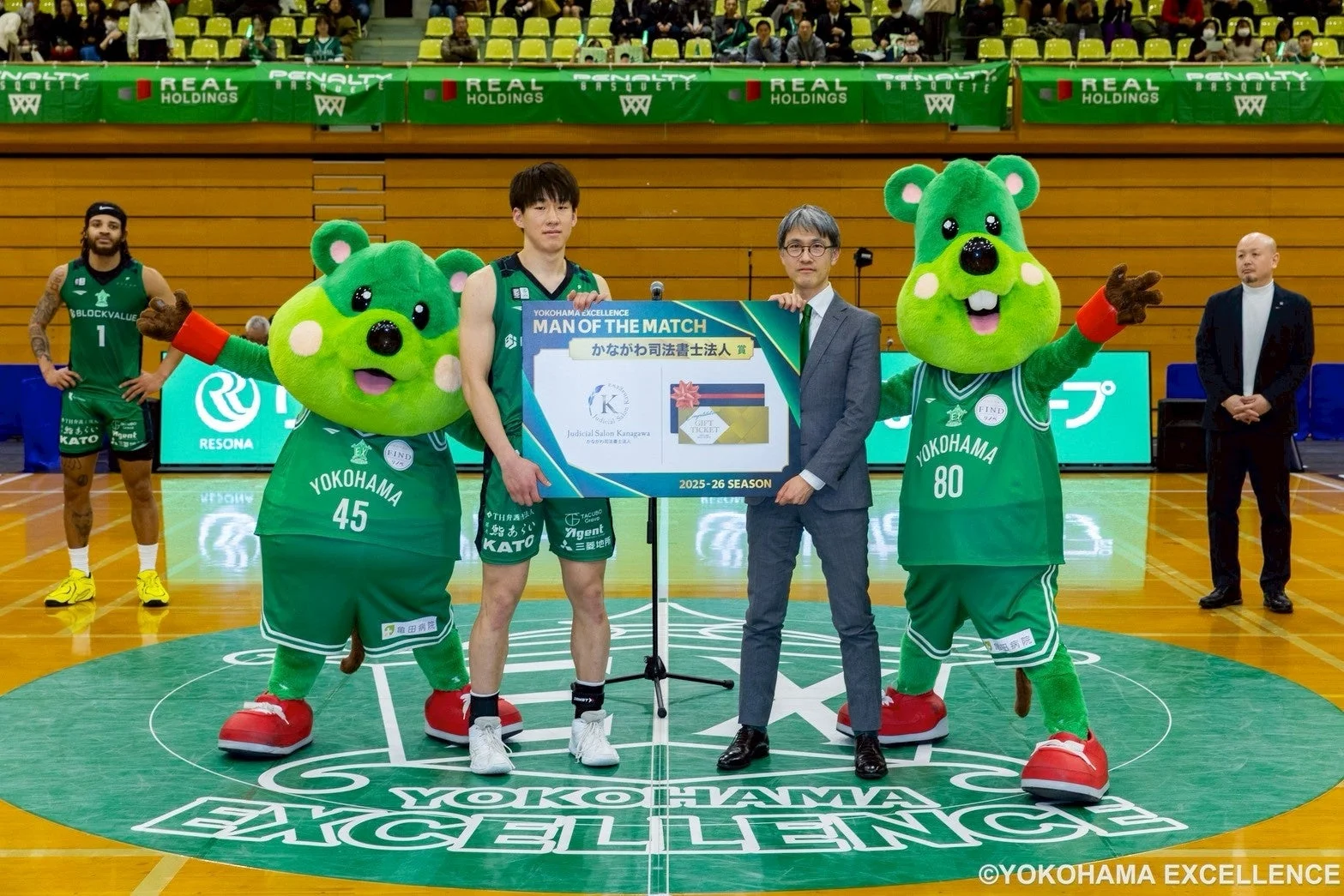 横浜エクセレンスのバスケットボール選手が、試合後のMAN OF THE MATCHとして表彰されている場面