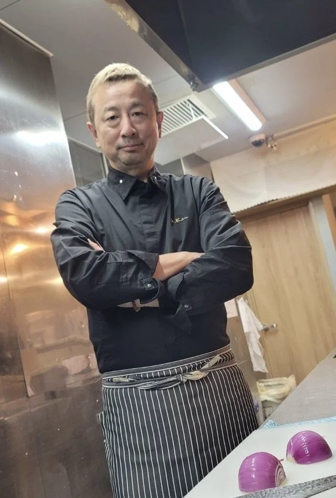 厨房で腕を組むシェフの韓洋さん