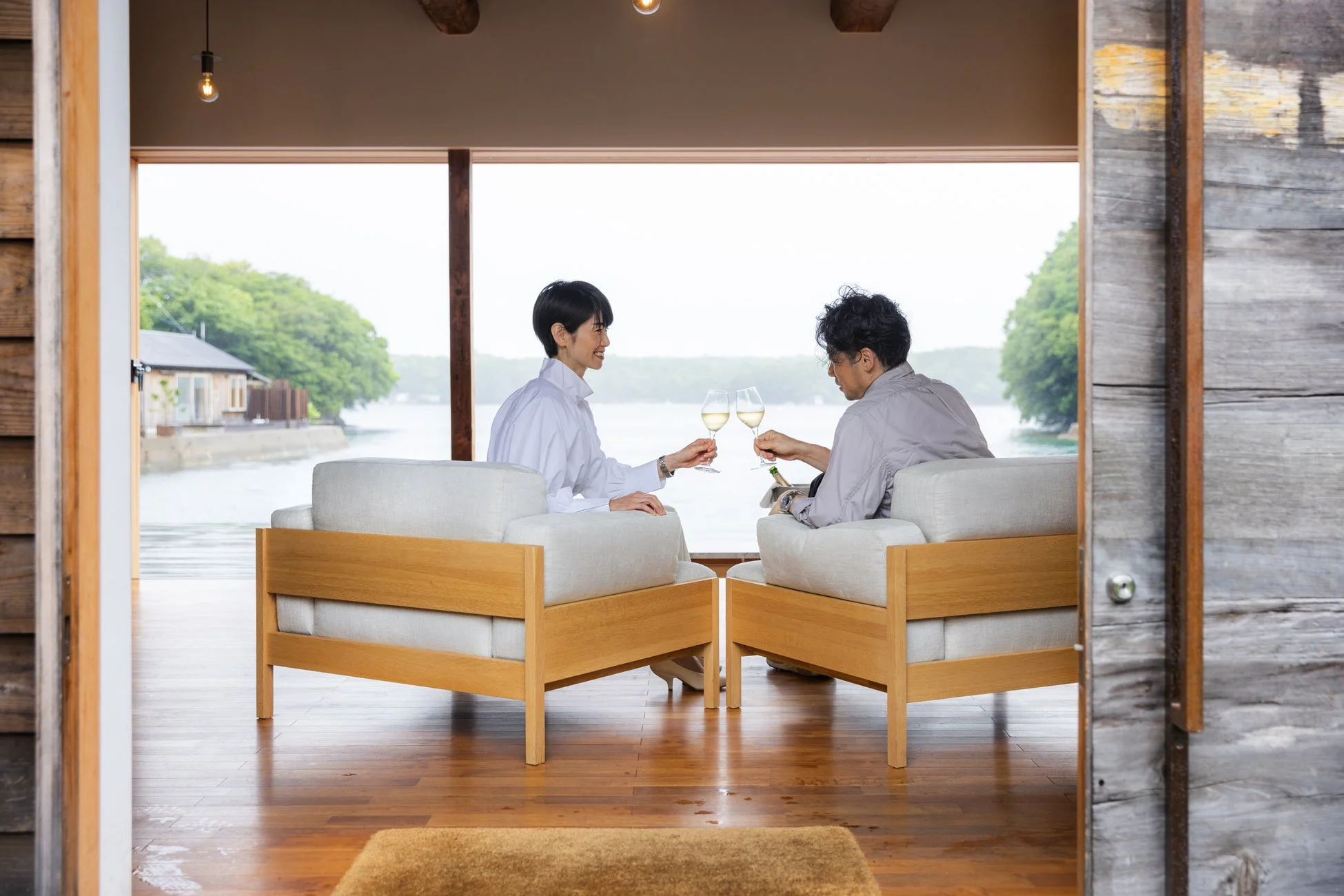 窓辺でワインを片手に景色を楽しむカップル