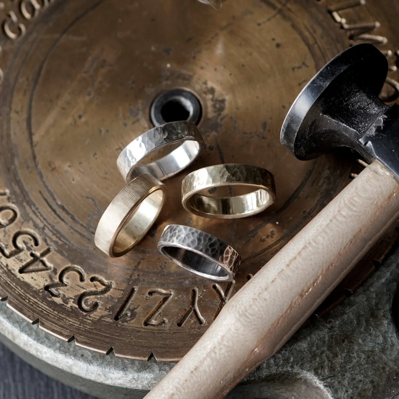 アンティーク調の金属板の上に置かれた複数の指輪